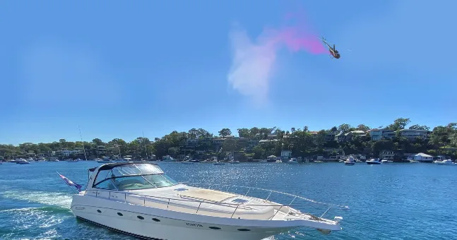 Luxury yacht on Biscayne Bay with gender reveal smoke overhead
